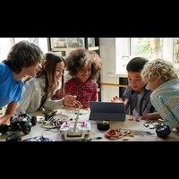 Children using a tablet and electronic components to build a robot in a modern classroom at the Best International School in Bangalore.